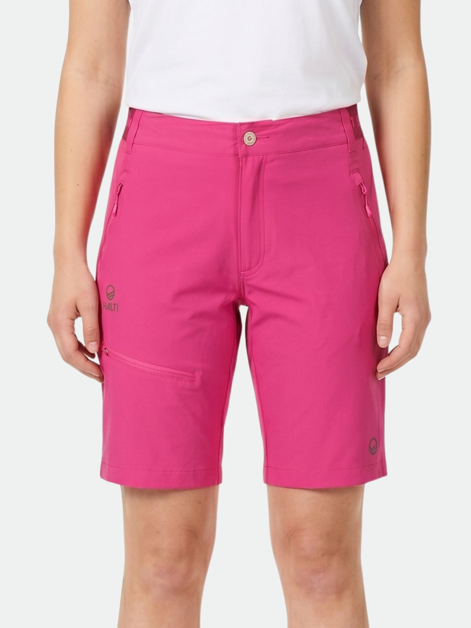 Henkilöllä on yllään vaaleanpunaiset Halti Pallas Naisten X-stretch Lite Shortsit ja valkoinen paita valkoista taustaa vasten.