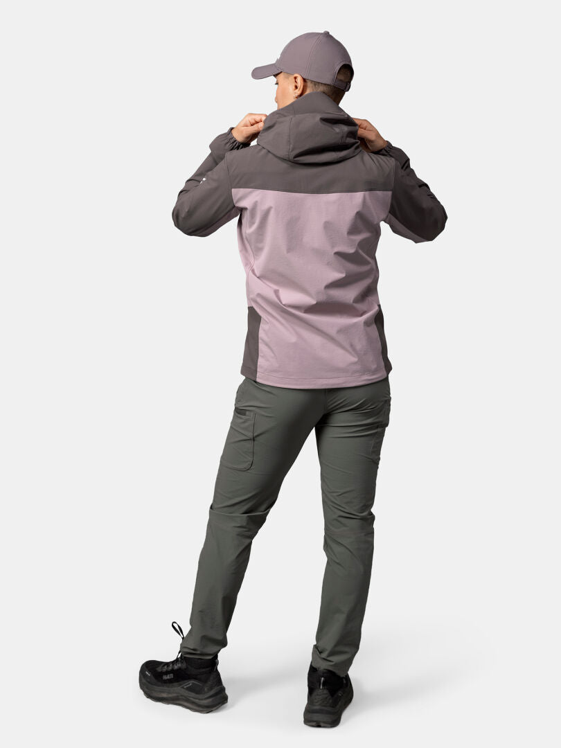 Henkilö seisoo selkä kameraan päin Halti Pallas Evo X-stretch Takki Naisten hupussa ja säätää huppua.