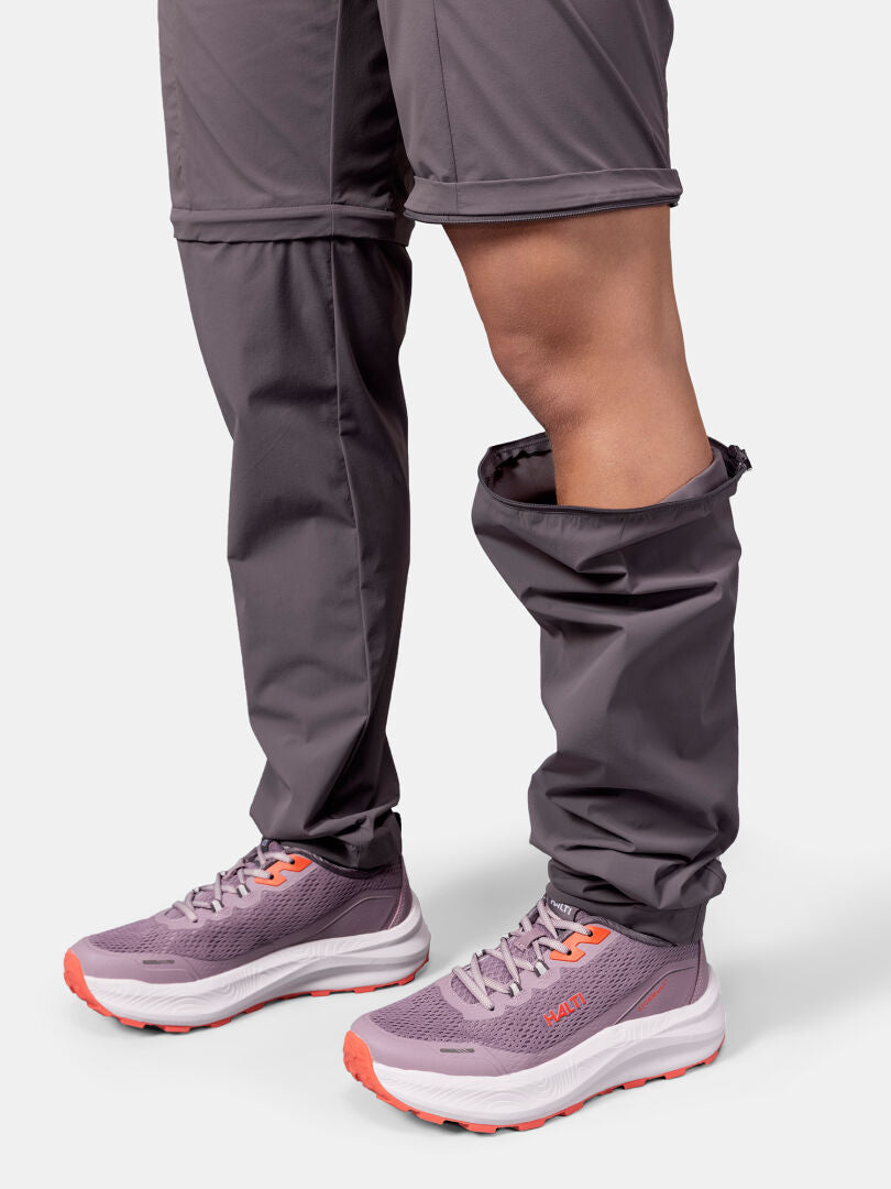 Henkilöllä on yllään Halti Pallas Cool Stretch Zip-off Housut Naisten housut, joiden lahkeet ovat osittain auki ja rullattu alas.