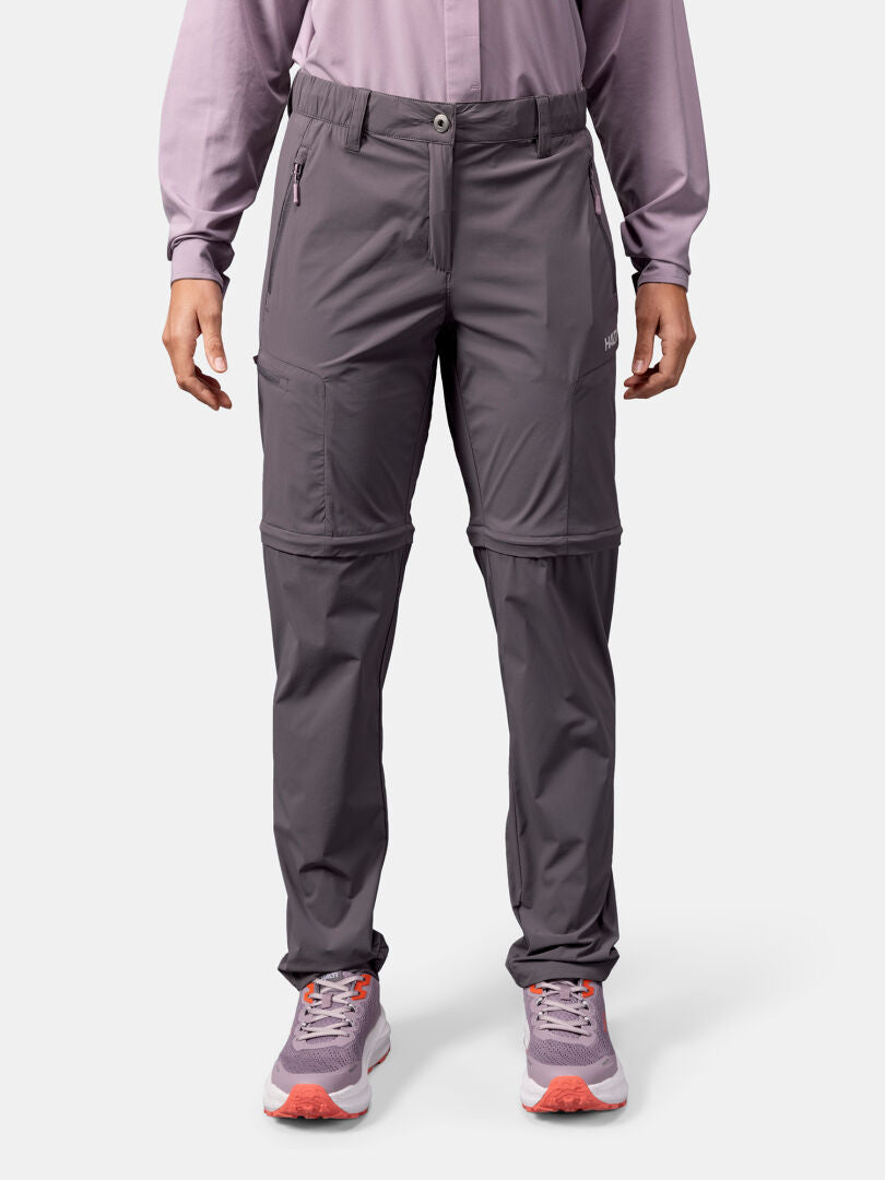 Henkilöllä on yllään Halti Pallas Cool Stretch Zip-off -takki, vaaleanvioletti pitkähihainen paita ja vaaleanvioletit lenkkarit.