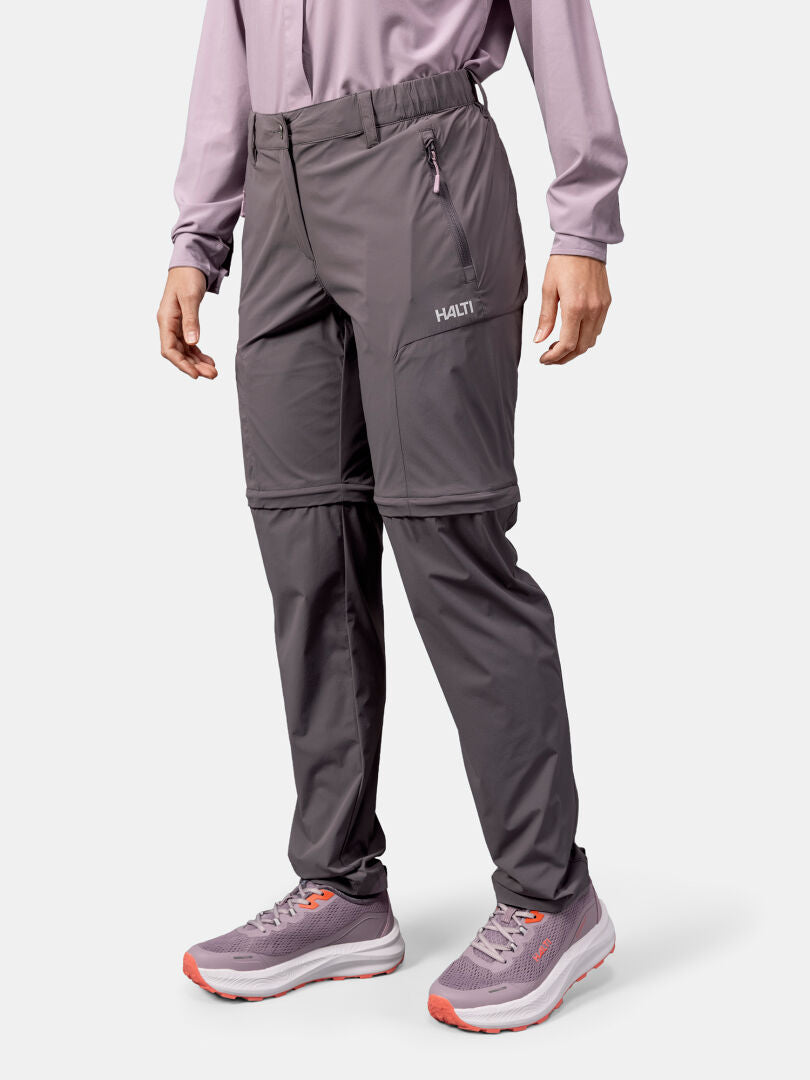 Päälläni Halti Pallas Cool Stretch Zip-off Housut Naisten, pitkähihainen paita ja vaaleanpunaharmaat tennarit.