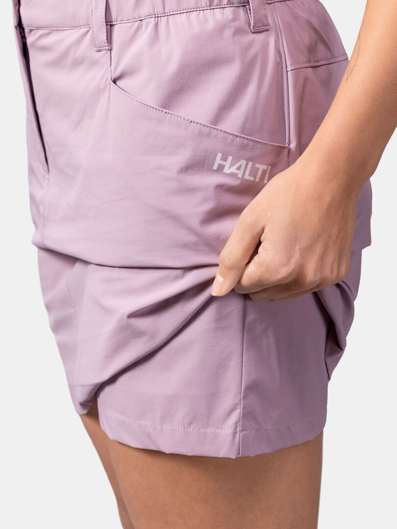 Henkilö venyttää kuivaa Quick Stretch Cool -kangasta laventelinväristä Halti Pallas Cool Shortsihame, joka sopii kesähameeseen.