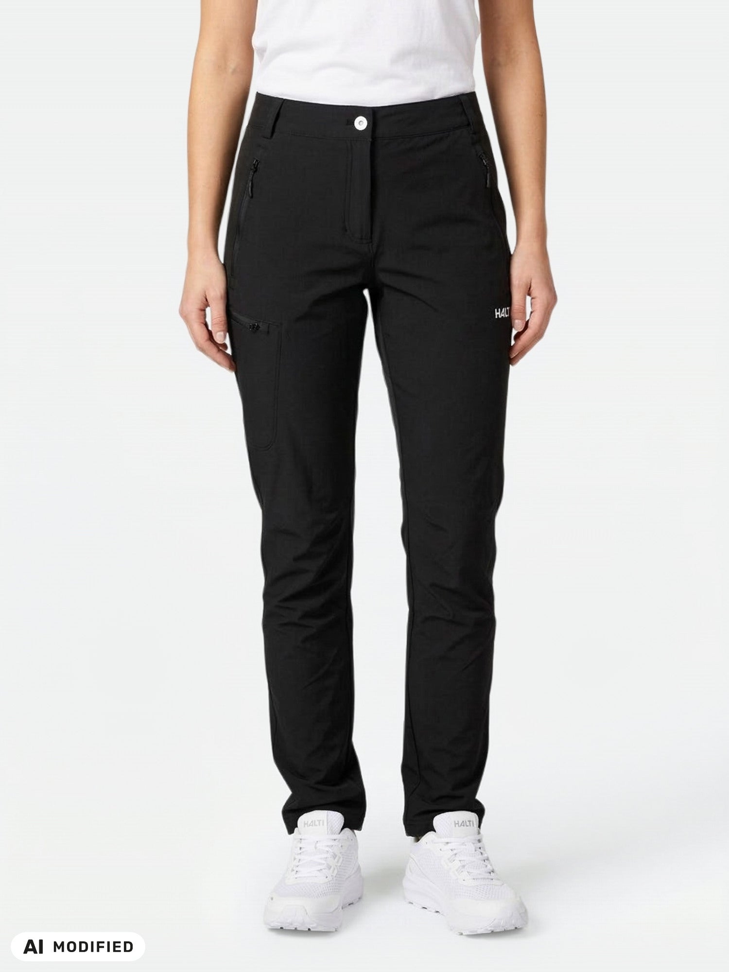 Nainen, jolla on yllään Halti Pallas X-stretch -ulkoiluhousut; kuvassa näkyy vain alavartalo valkoisissa lenkkareissa, vaalea yksivärinen tausta.