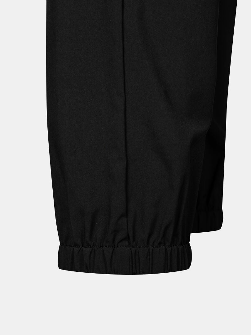 Lähikuvassa Halti Grets Joggersit Naisten, joissa on joustavat hihansuut ja Quick Dry Lite Stretch -kangas yksiväristä taustaa vasten.