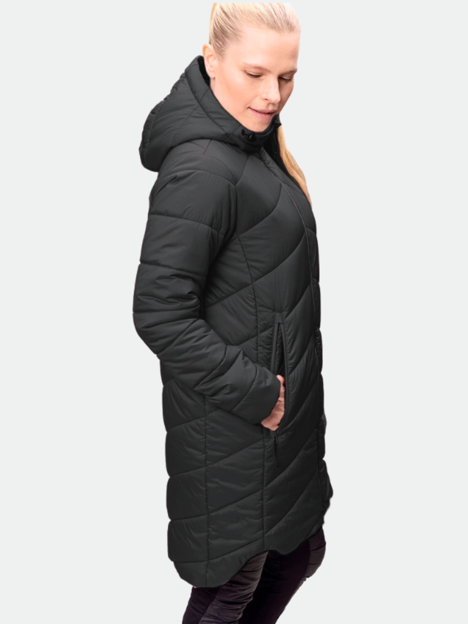 Henkilöllä on yllään Halti Komu Pitkä Kevytvanuparka Naisten pitkä musta tikattu naisten parka, jossa on huppu ja taskut.