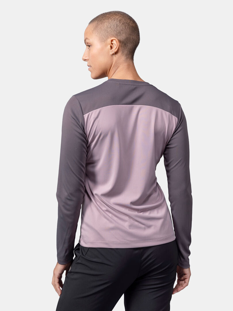 Lyhythiuksisella henkilöllä on Halti Salves Treenipaita Naisten ja mustat housut, kuvattu selästä tavallisella taustalla.