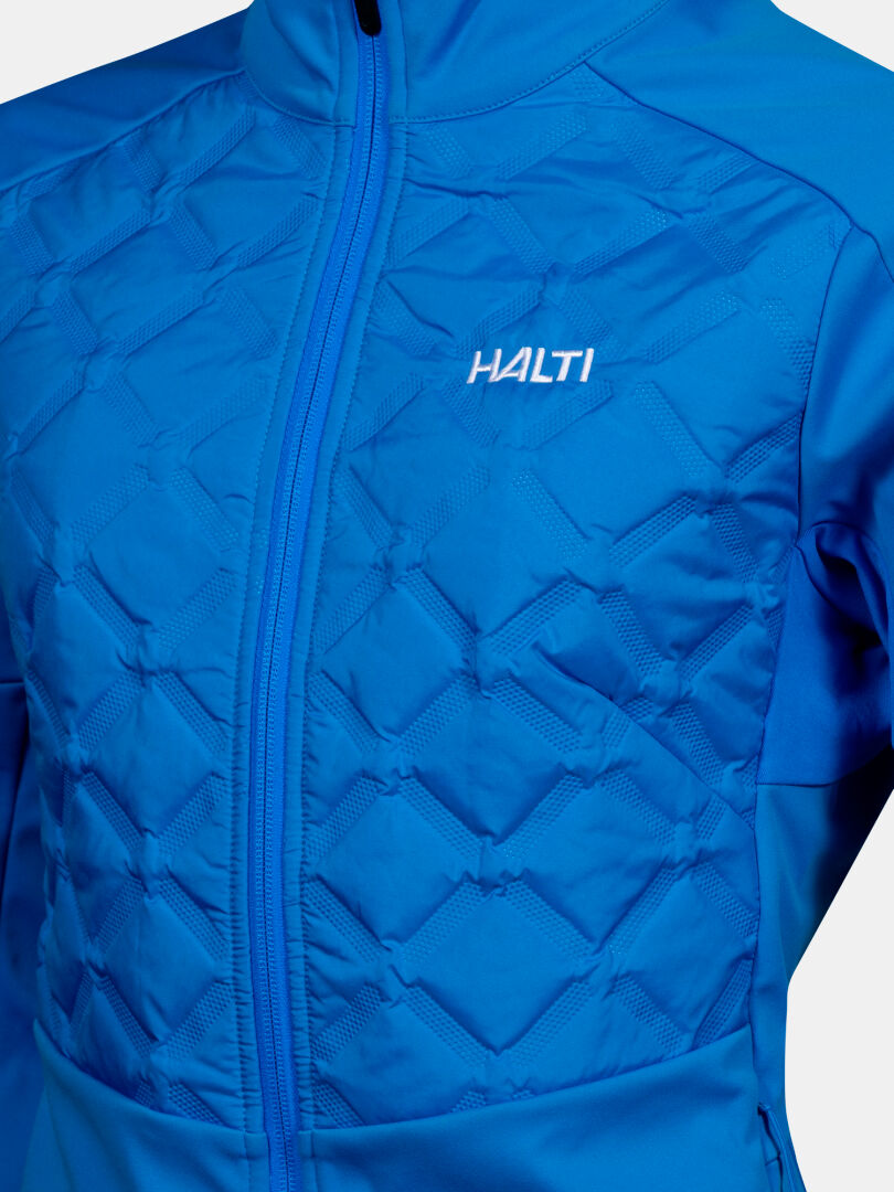 Lähikuva sinisestä Halti Framover Hybrid Hiihtotakki Naisten softshell-takista, jossa on vetoketju ja logo rinnassa.
