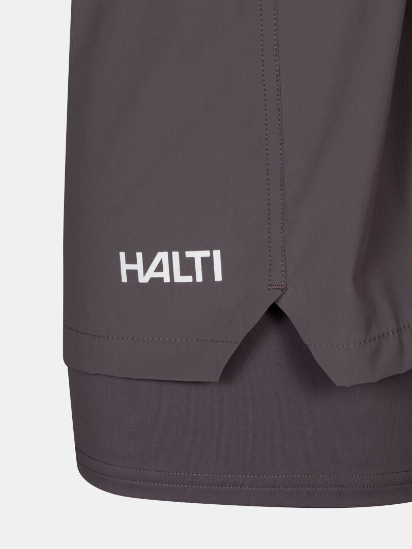 Lähikuva Uurto Shortsit Naisten Halti-logolla varustetusta Uurto Shortsit Naisten sivuhalkiosta ja nopeasti kuivuvasta kankaasta.