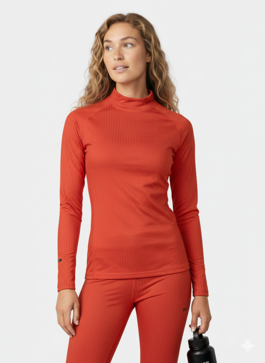 Kierrätyspolyesteristä valmistetussa Halti Dual Kerrasto Naisten vaatteessa oleva nainen pitelee mustaa vesipulloa valkoisella pohjalla.